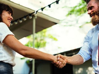 Frau schüttelt Hausbauberater die Hand Frau schüttelt Hausbauberater die Hand