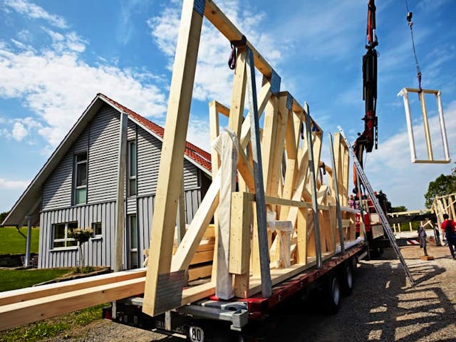 Der vorgefertigte Holzrahmen einer Wand wird angeliefert. Dämmmaterial und Wandabschlüsse werden auf der Baustelle montiert. Foto: Ingo Bartussek / stock.adobe.com