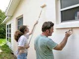 Fassade streichen, Vater und Tochter streichen die Fassade, Farbroller, Pinsel, Foto: iStock / lisafx
