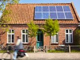 Photovoltaikanlage auf dem Dach eines Backsteinhauses, Foto: ideeone / iStock