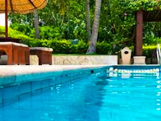 Pool, Bild eines Pools mit zwei Liegestühlen an der Seite und Bäumen im Hintergrund, Foto: iStock.com / baona Pool, Bild eines Pools mit zwei Liegestühlen an der Seite und Bäumen im Hintergrund, Foto: iStock.com / baona