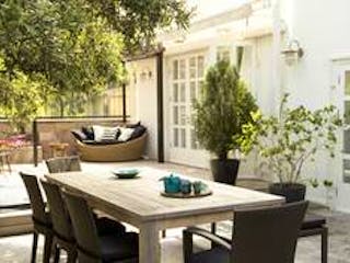 Terrasse, Bild einer Terasse mit großem Esstisch in der Mitte und bequemen Sitzgelegenheiten im Hintergrund vor einem weißen modernem Haus, Foto: iStock.com / penguenstok Terrasse, Bild einer Terasse mit großem Esstisch in der Mitte und bequemen Sitzgelegenheiten im Hintergrund vor einem weißen modernem Haus, Foto: iStock.com / penguenstok