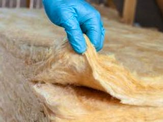 Dämmstoffe, Mineralwolle, blauer Handschuh, Foto: pashapixel / iStock