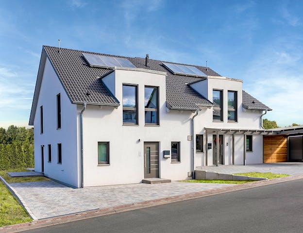 Ein Doppelhaus muss nicht symmetrisch sein. Bei diesem modernen Doppelhaus-Fertighaus von Hanse Haus weichen die beiden Seiten voneinander ab, auch wenn der Stil der gleiche ist.