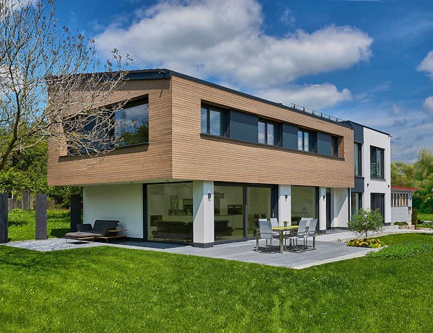 So wurde ein Haus aus dem Katalog auf Grundlage persönlicher Wünsche individuell umgewandelt: Außergewöhnliches Fertighaus mit Flach- und Pultdach sowie kombinierter Holz- und Putzfassade von Keitel-Haus