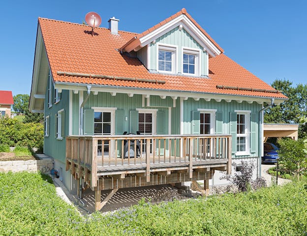 Typisches amerikanisches Holzhaus mit Holzfassade und Veranda von Rems-Murr-Holzhaus