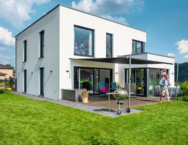 So wurde ein Haus aus dem Katalog auf Grundlage persönlicher Wünsche individuell umgewandelt: Außergewöhnliches Fertighaus mit Flachdach, angeschlossener Doppelgarage & Rechteckerker mit bodentiefen Fenstern von WeberHaus